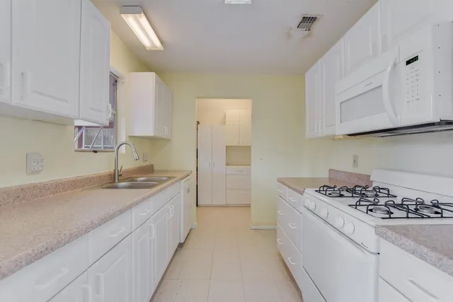 a kitchen with a sink stove and cabinets