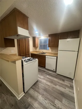 a kitchen with a sink a refrigerator and a stove top oven