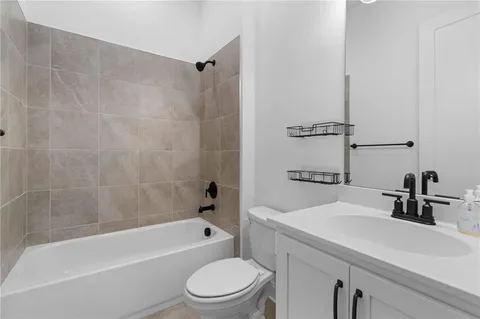 a bathroom with a sink a toilet a mirror a bathtub and shower