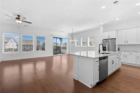 a large kitchen with stainless steel appliances granite countertop a stove and a large window