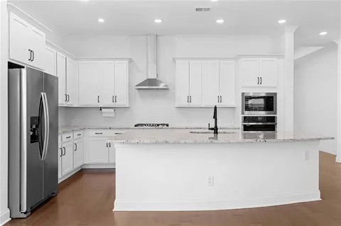 a kitchen with stainless steel appliances granite countertop a refrigerator a stove and a sink