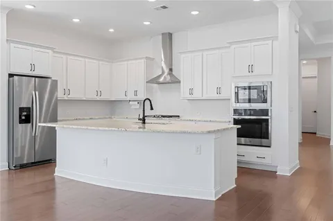 a kitchen with stainless steel appliances granite countertop a sink and a refrigerator