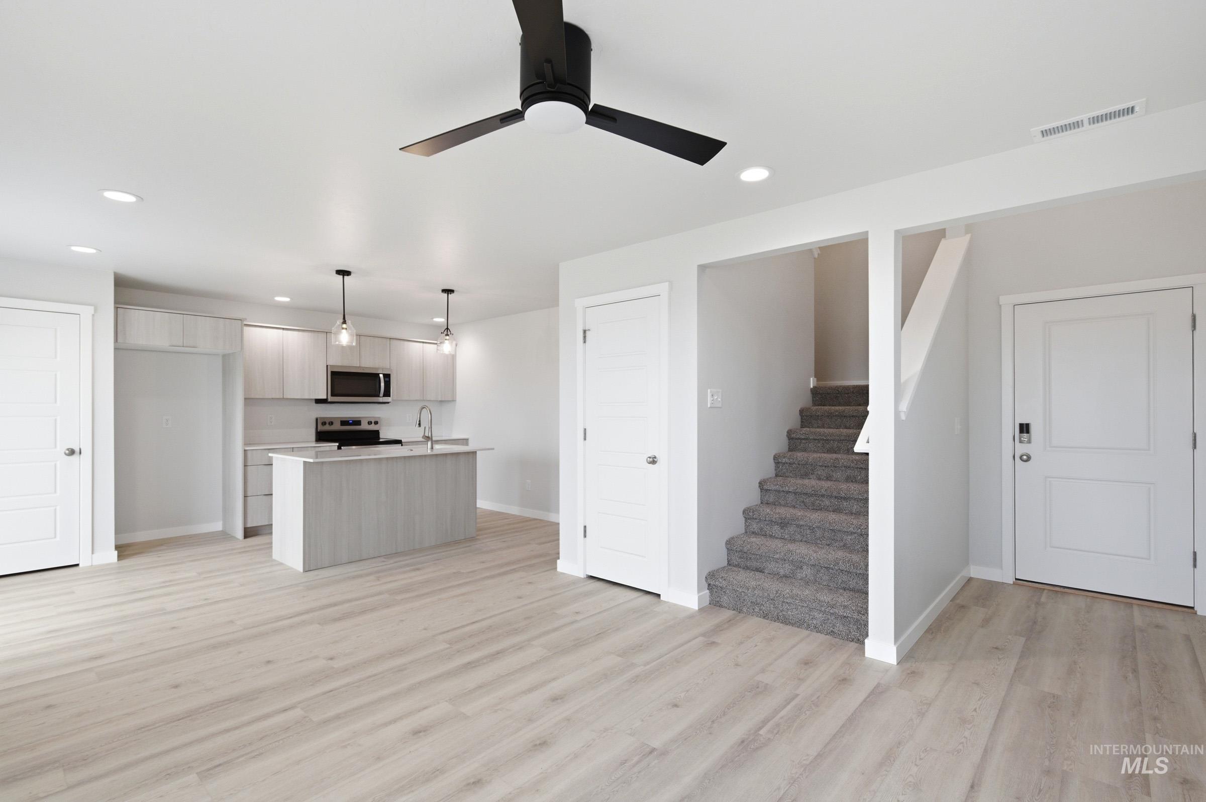 10788 Rutland Street Caldwell, ID 83605 - Photo 22 of 22 Kitchen featuring light countertops, pendant lighting, a kitchen island with sink, stainless steel appliances, and open floor plan