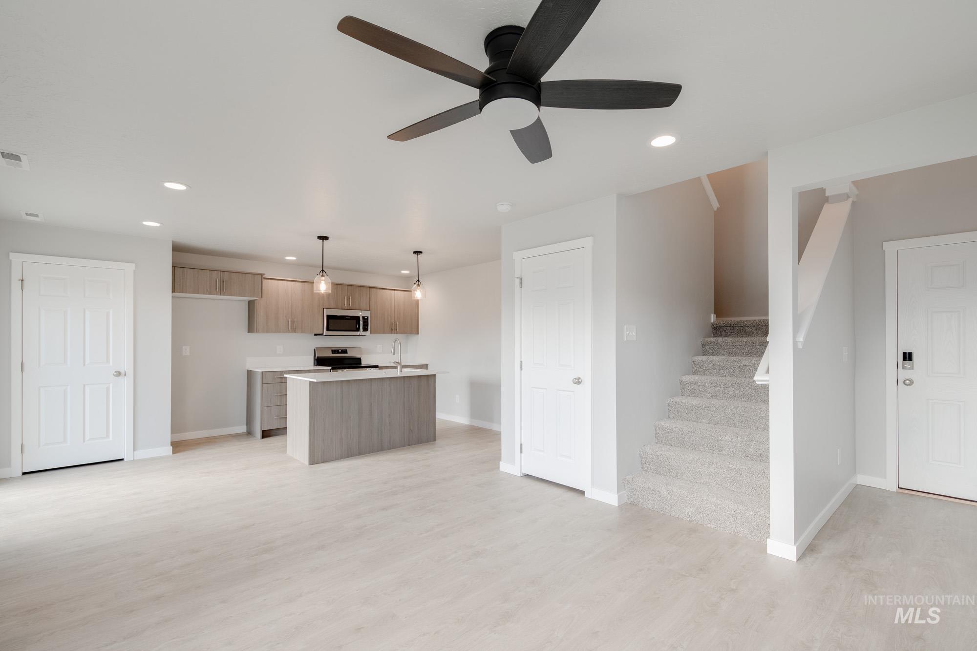 10788 Rutland Street Caldwell, ID 83605 - Photo 22 of 22 Kitchen with light countertops, a kitchen island with sink, modern cabinets, decorative light fixtures, and open floor plan