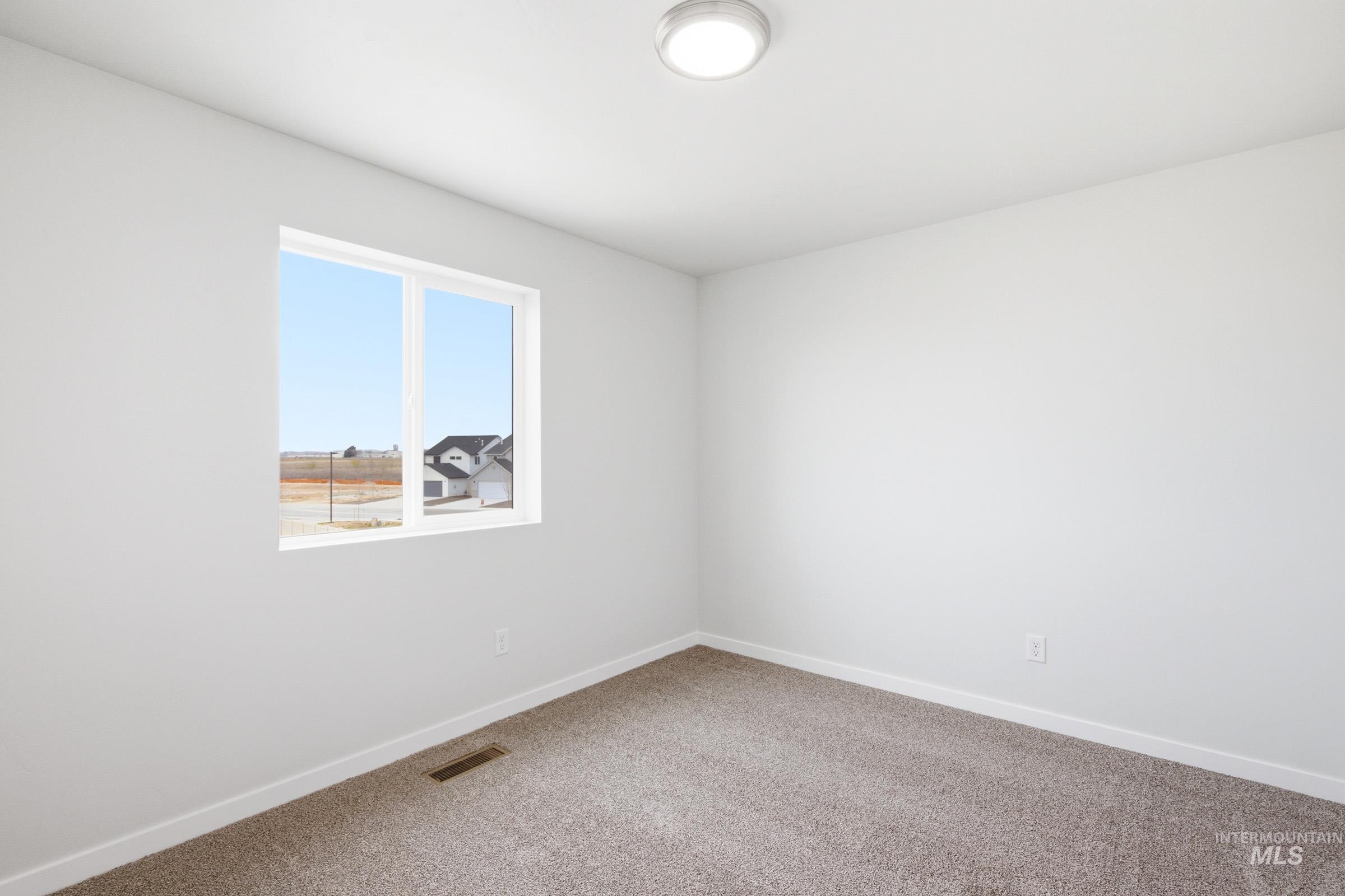 10788 Rutland Street Caldwell, ID 83605 - Photo 14 of 22 Empty room featuring light colored carpet and baseboards