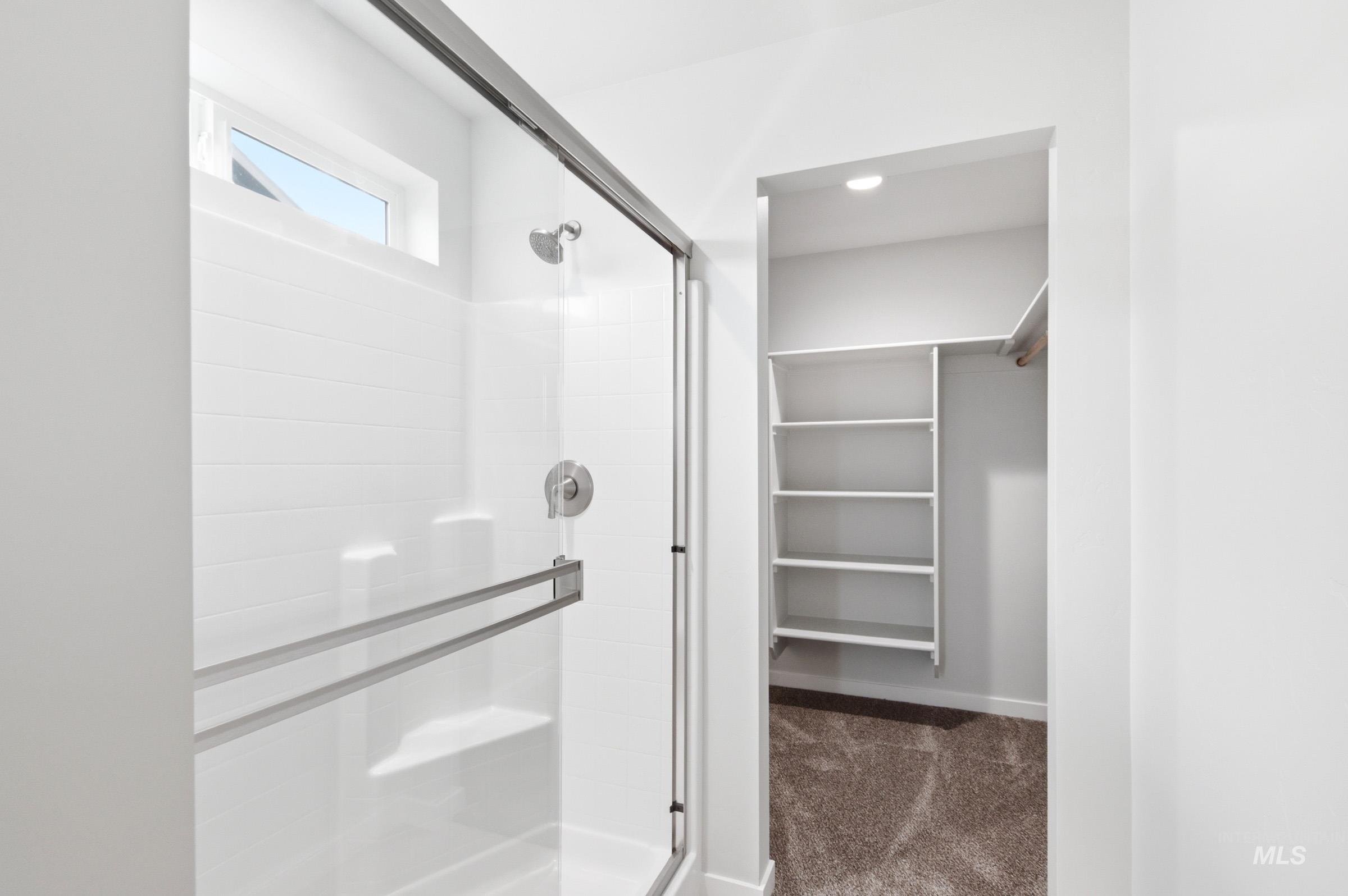 10788 Rutland Street Caldwell, ID 83605 - Photo 18 of 22 Full bathroom with a spacious closet, a shower stall, and dark colored carpet