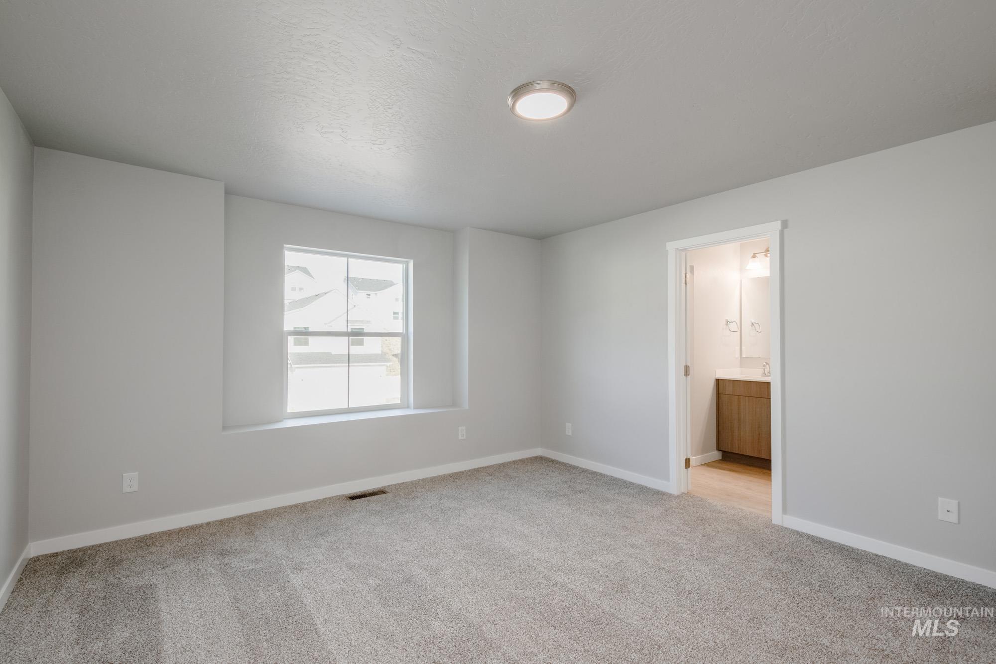 10788 Rutland Street Caldwell, ID 83605 - Photo 16 of 22 Unfurnished bedroom with light carpet and ensuite bath