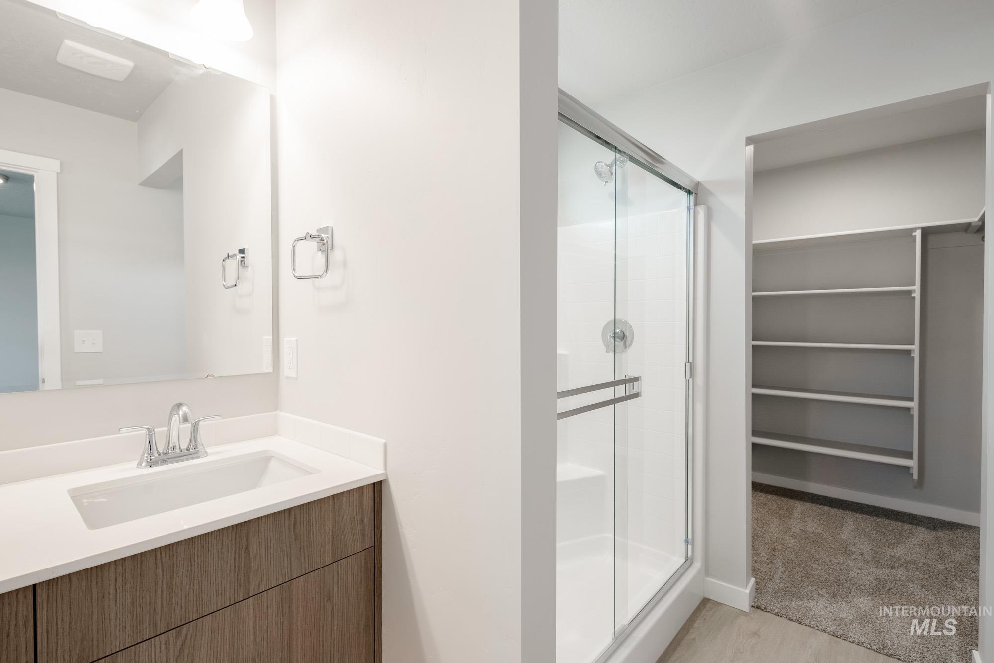 10788 Rutland Street Caldwell, ID 83605 - Photo 17 of 22 Bathroom featuring a stall shower, vanity, and a walk in closet