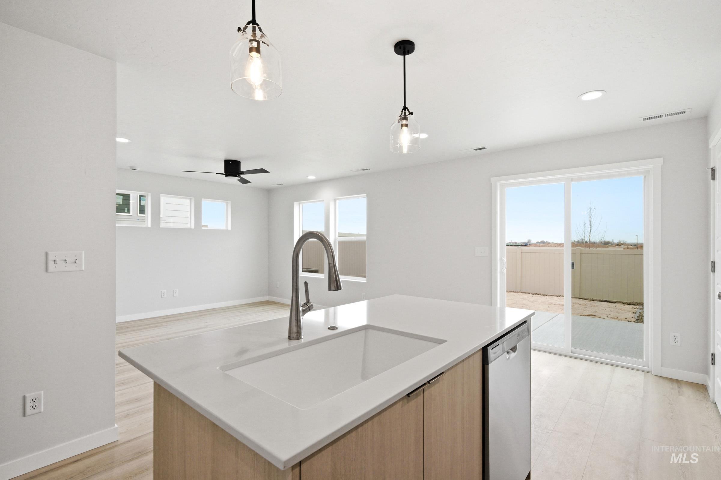 10788 Rutland Street Caldwell, ID 83605 - Photo 8 of 22 Kitchen with a center island with sink, pendant lighting, dishwasher, modern cabinets, and light stone counters
