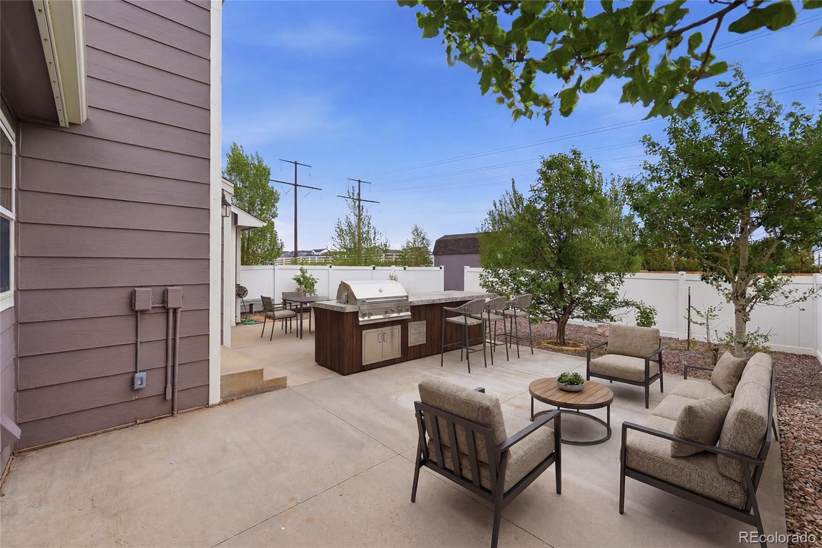 9288 Rockingham Drive Peyton, CO 80831 - Photo 35 of 49 a view of a patio with couches and potted plants on a table and chairs