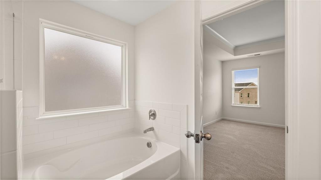 421 Hazel Drive Locust Grove, GA 30248 - Photo 22 of 28 a white bath tub sitting next to a shower