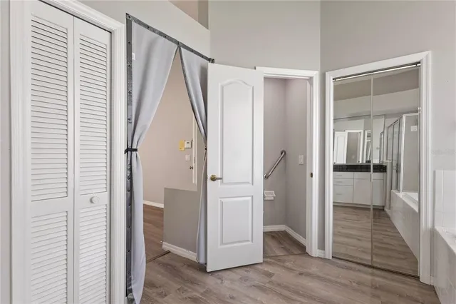a view of a hallway with wooden floor and closet area