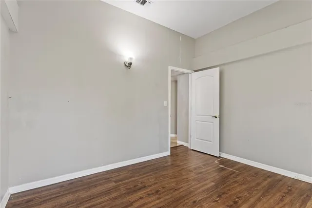 a view of an empty room with wooden floor