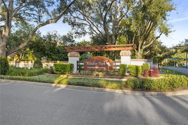 a view of a house with a yard and large tree