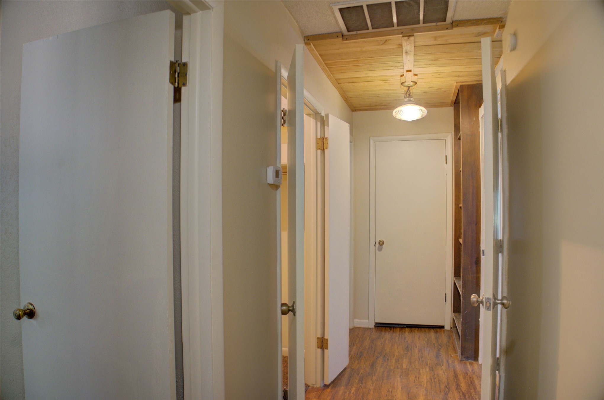 12420 South Garnett Road Broken Arrow, OK 74011 - Photo 28 of 44 Wood-finish flooring throughout the hallway with multiple white panel doors