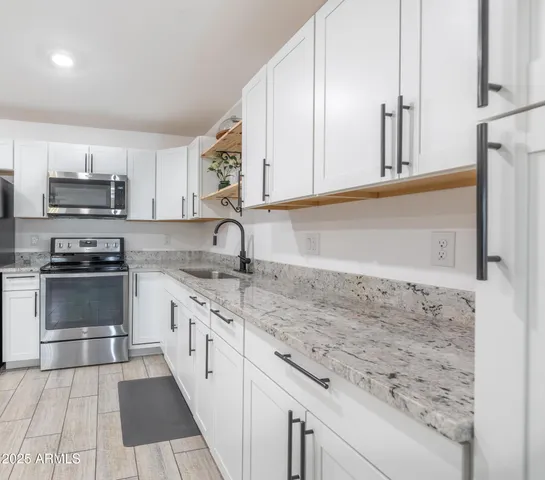a kitchen with stainless steel appliances granite countertop a sink and cabinets