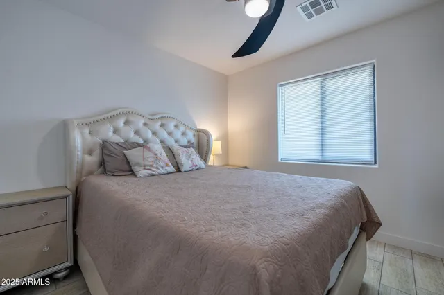 a large bed sitting in a bedroom next to a window