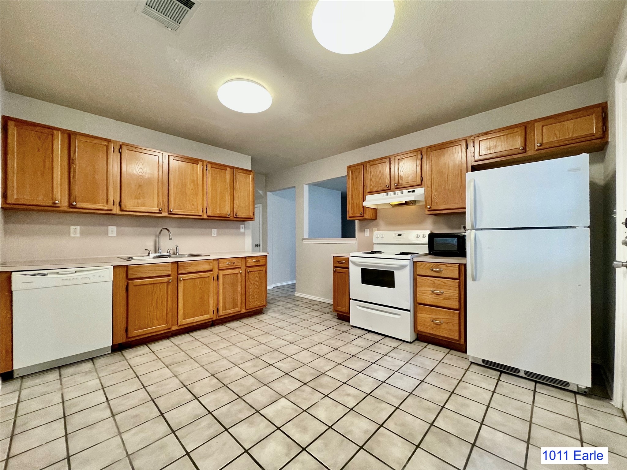 1007-1015 Earle Street San Marcos, TX 78666 - Photo 16 of 25 a kitchen with a stove a sink and a refrigerator