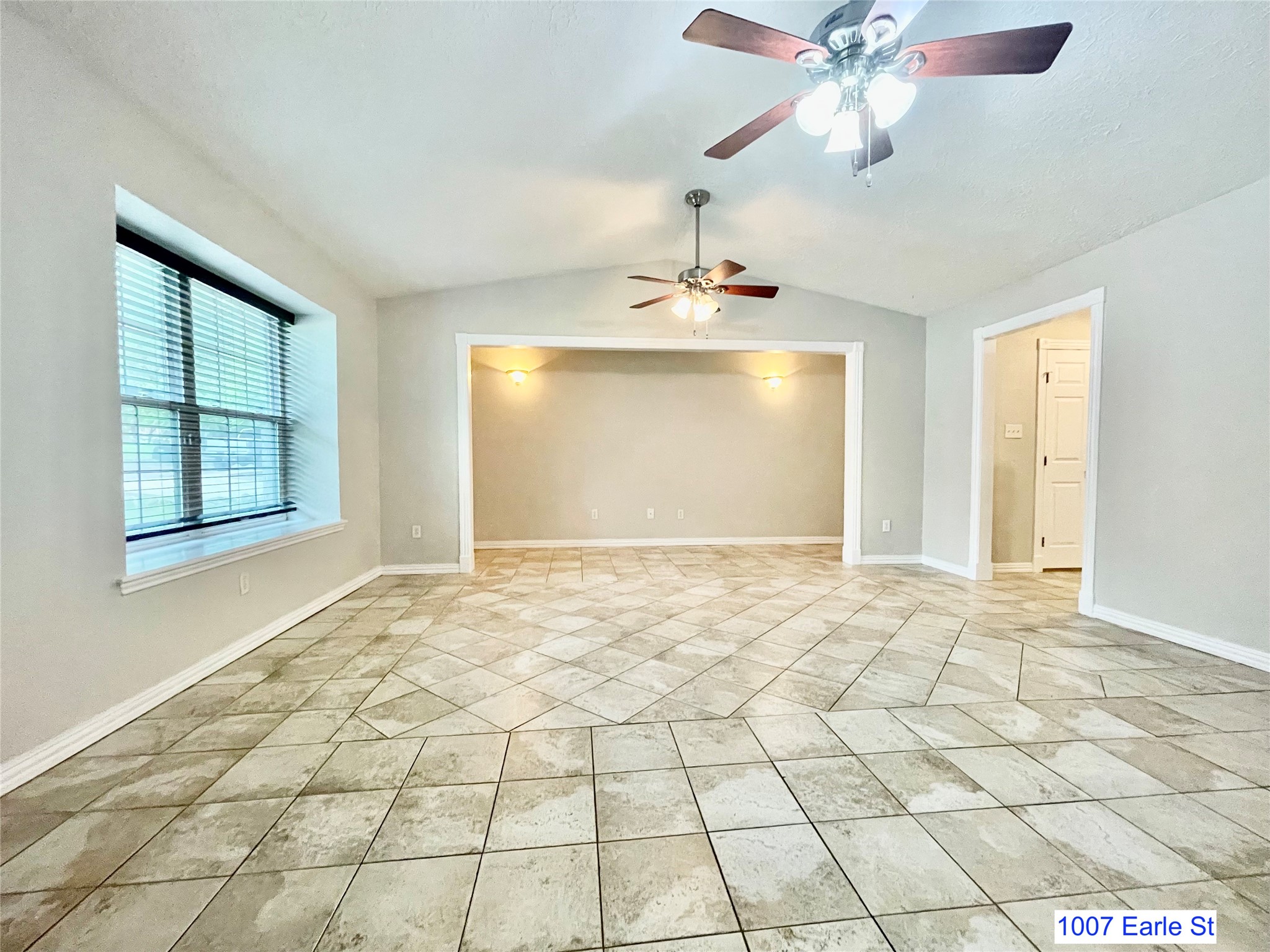 1007-1015 Earle Street San Marcos, TX 78666 - Photo 3 of 25 a view of an empty room and window and chandelier fan