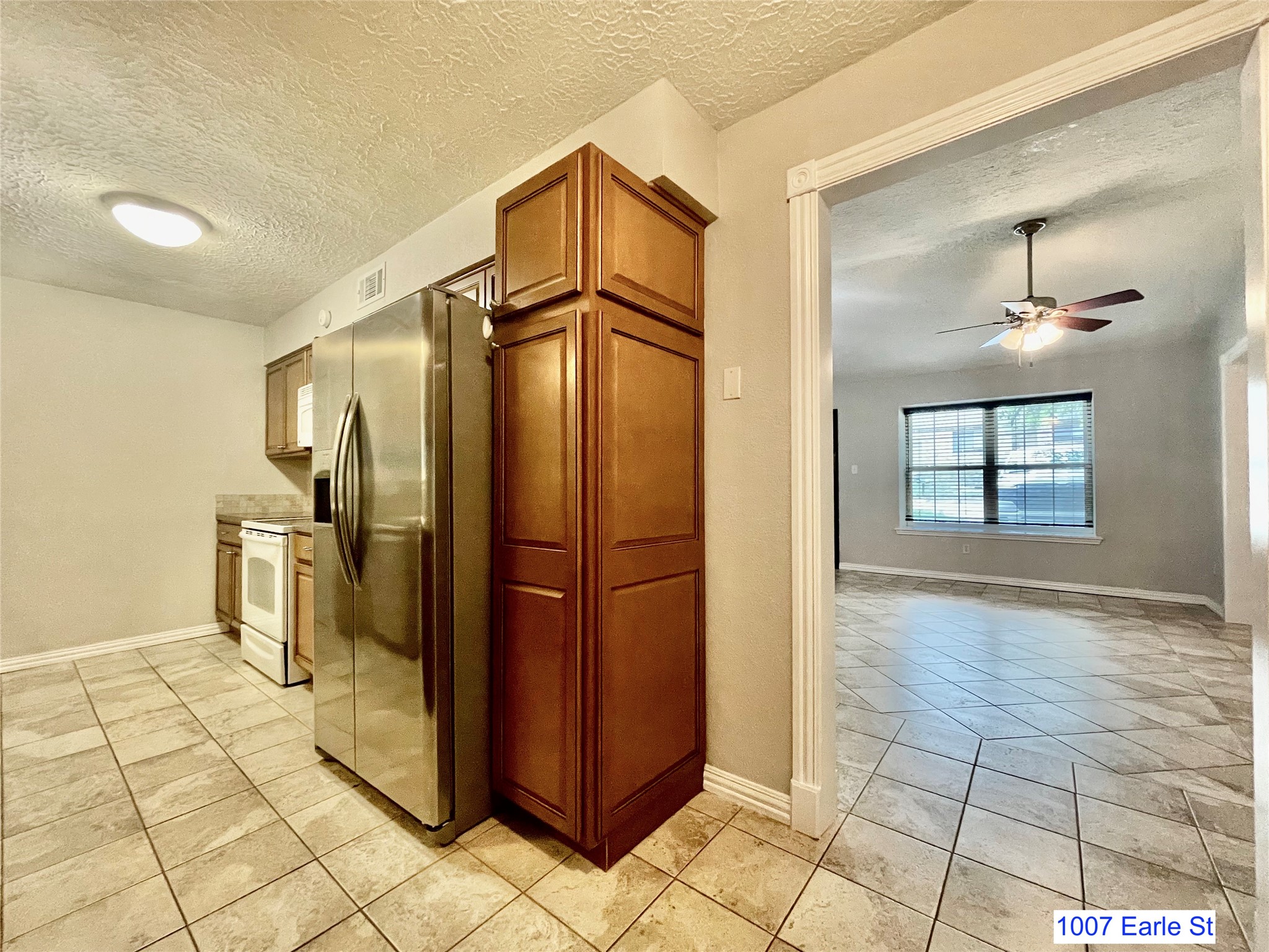 1007-1015 Earle Street San Marcos, TX 78666 - Photo 5 of 25 a view of a refrigerator in kitchen and an empty room