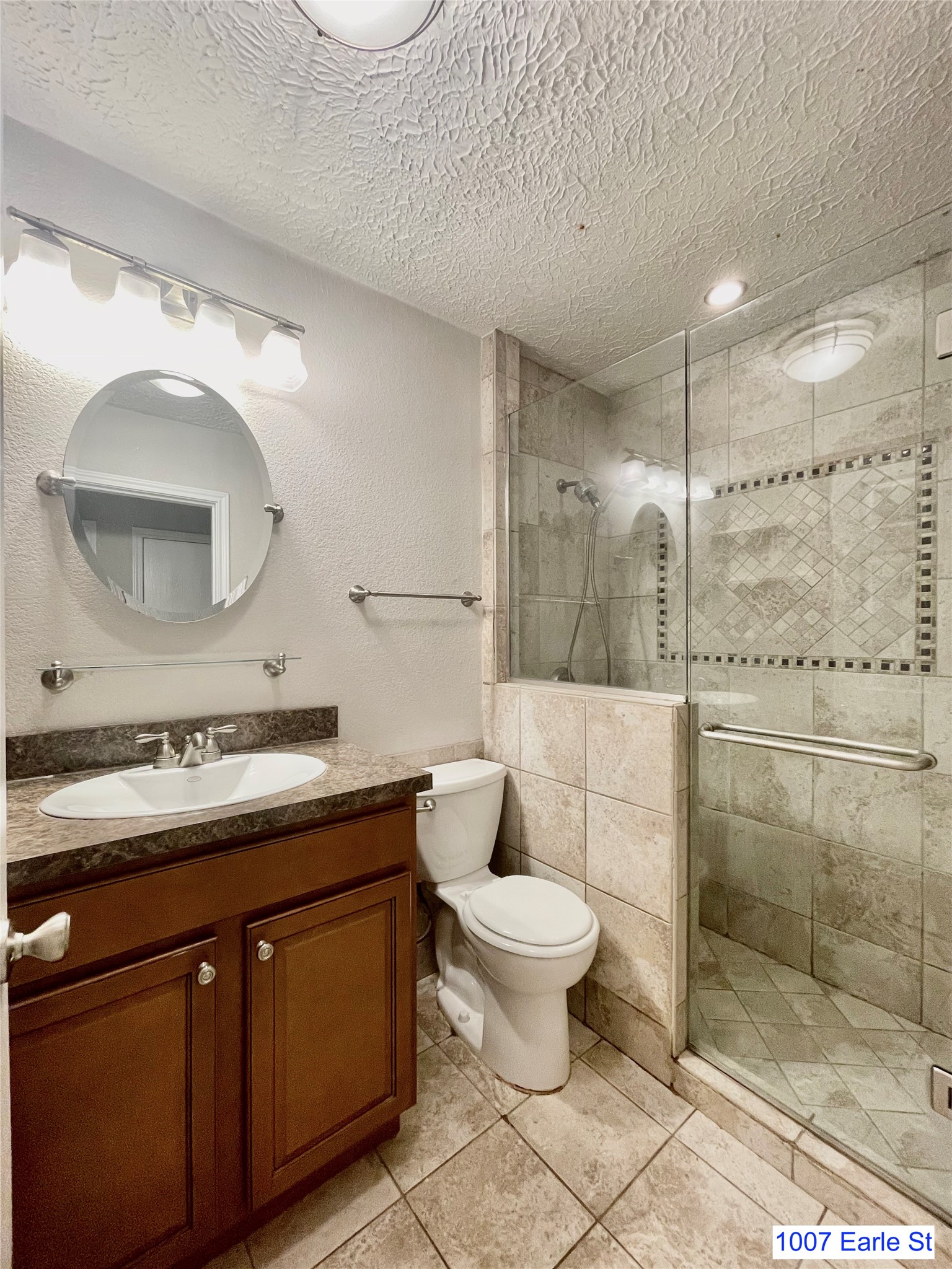 1007-1015 Earle Street San Marcos, TX 78666 - Photo 10 of 25 a bathroom with a toilet sink mirror and vanity