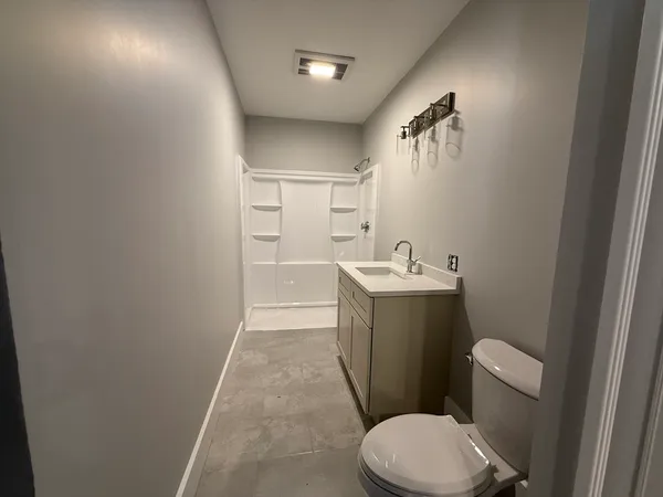 a bathroom with a sink vanity mirror and toilet