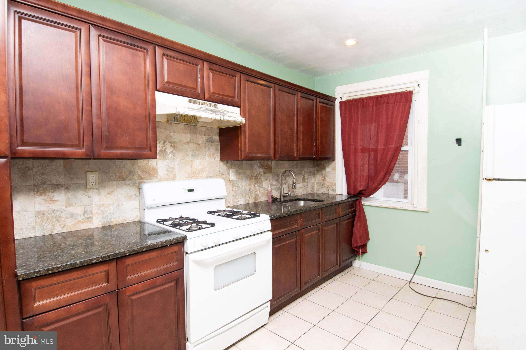 291 Sanford Road Upper Darby, PA 19082 - Photo 5 of 18 a kitchen with granite countertop a sink stove and cabinets