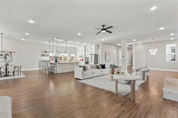 a living room with furniture kitchen view and a wooden floor