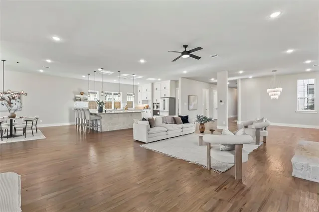 a living room with furniture kitchen view and a wooden floor