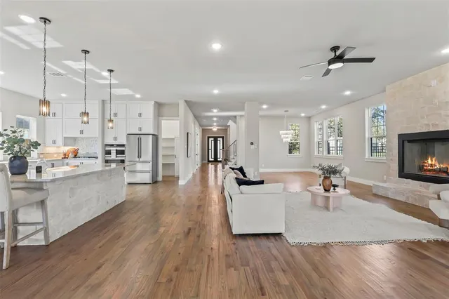 a kitchen with stainless steel appliances sink refrigerator dining table and chairs