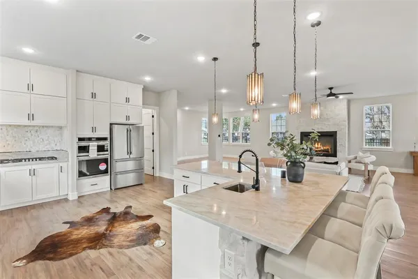 a kitchen with stainless steel appliances granite countertop a sink stove and refrigerator