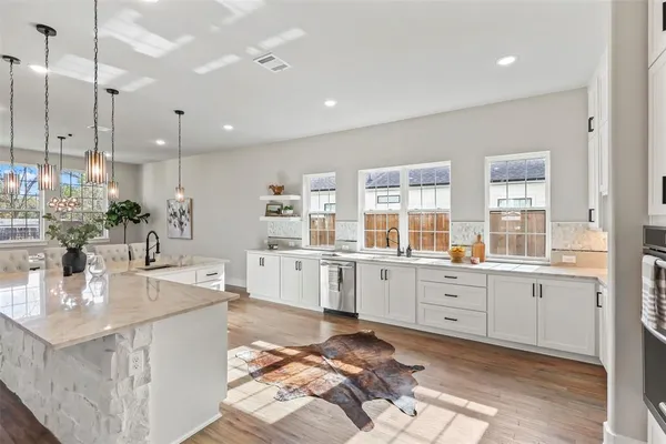 a large kitchen with kitchen island a stove a sink a center island a stove and a window