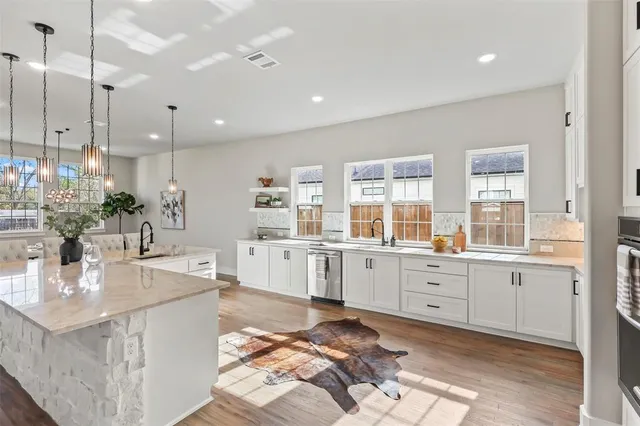 a large kitchen with kitchen island a stove a sink a center island a stove and a window