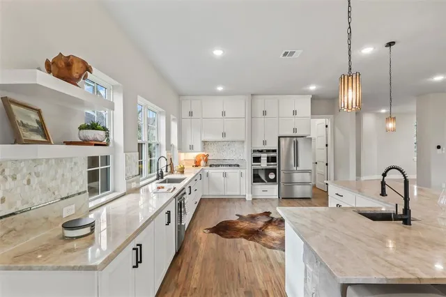 a dining hall with stainless steel appliances kitchen island granite countertop a stove a sink a dining table and chairs with wooden floor