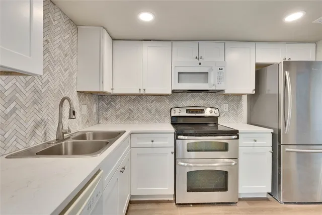 a kitchen with cabinets stainless steel appliances and a sink