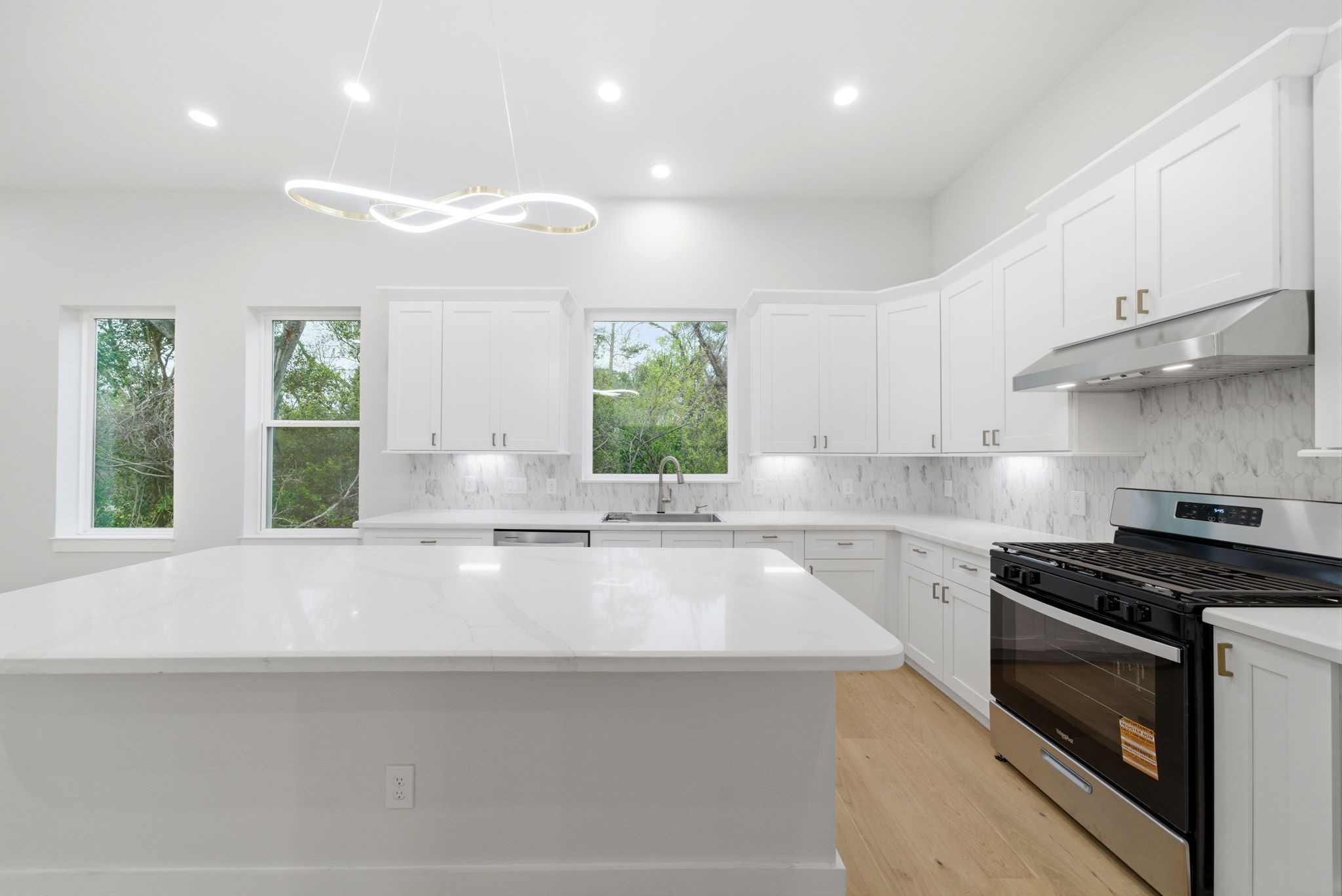 330 Janisch Road, Unit A Houston, TX 77018 - Photo 17 of 40 a kitchen with kitchen island granite countertop a stove a sink and a counter space