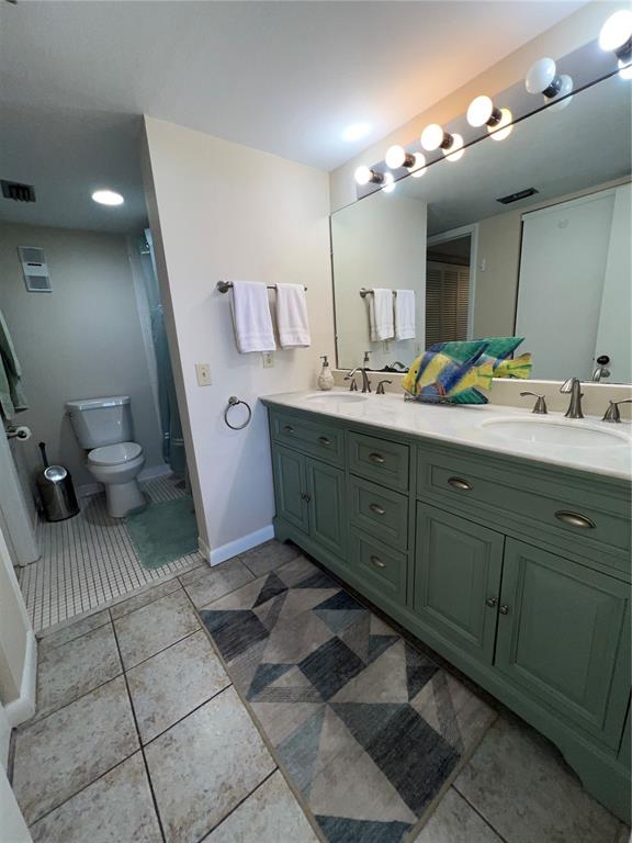5915 Sea Ranch Drive, Unit 512 Hudson, FL 34667 - Photo 16 of 55 a spacious bathroom with a double vanity sink a toilet and a mirror