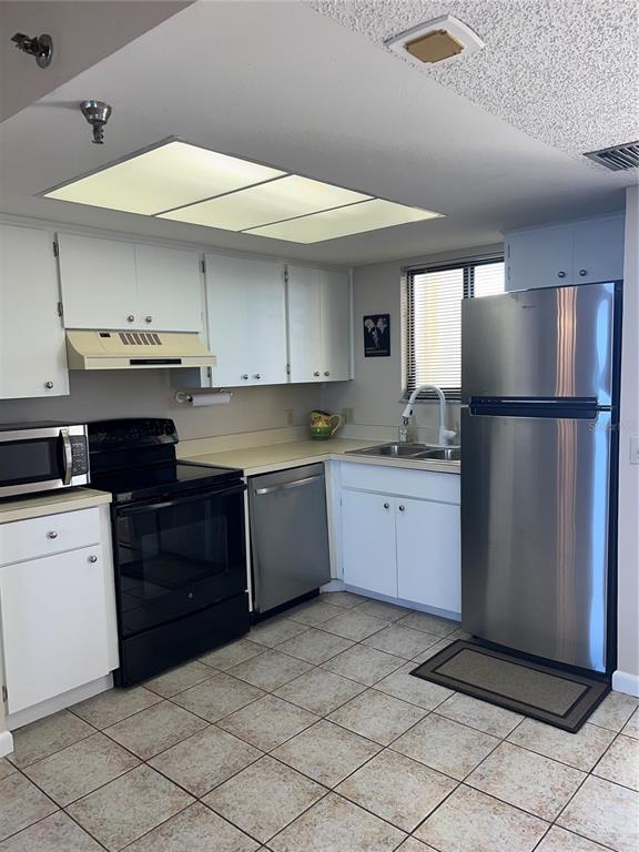 5915 Sea Ranch Drive, Unit 512 Hudson, FL 34667 - Photo 9 of 55 a kitchen with stainless steel appliances granite countertop a refrigerator and a stove