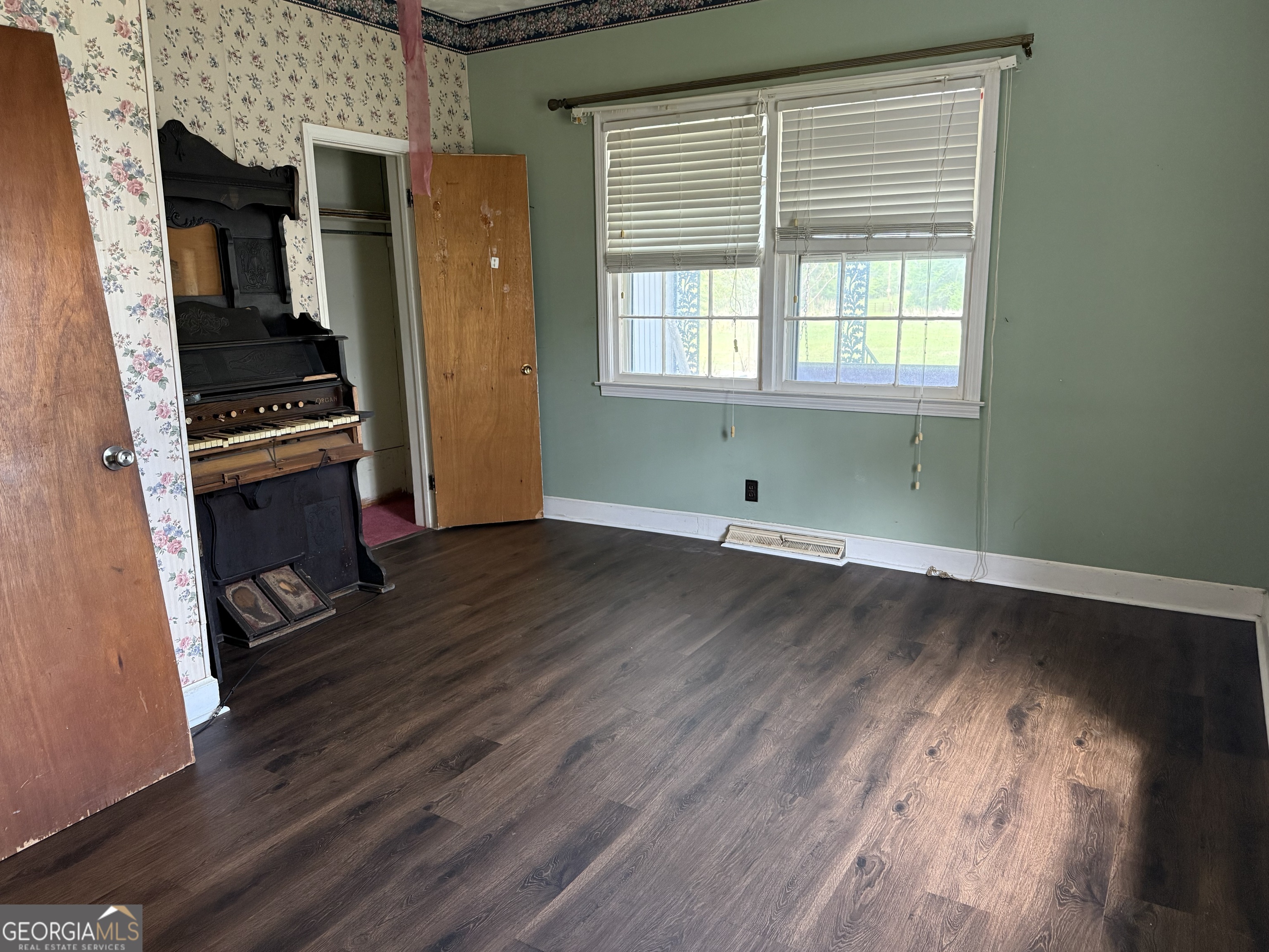 641 South Masonic Street Millen, GA 30442 - Photo 14 of 20 an empty room with wooden floor and windows