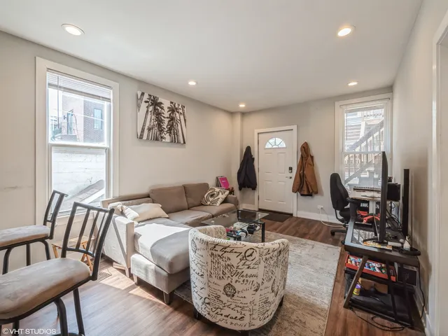 a living room with furniture a flat screen tv and a large window