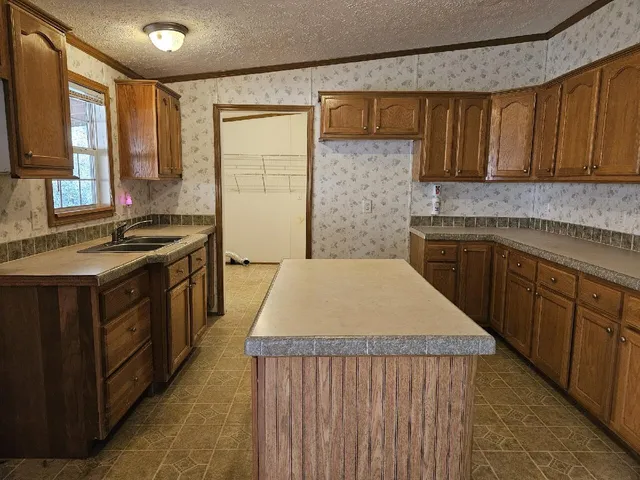 a kitchen with stainless steel appliances granite countertop wooden cabinets a sink and a stove