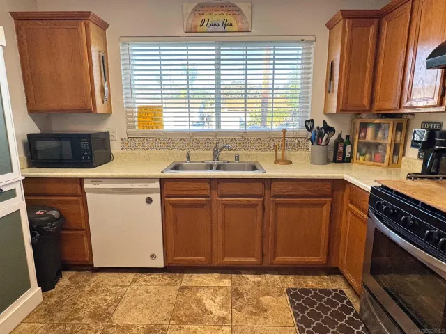 a kitchen with stainless steel appliances granite countertop a sink stove and cabinets
