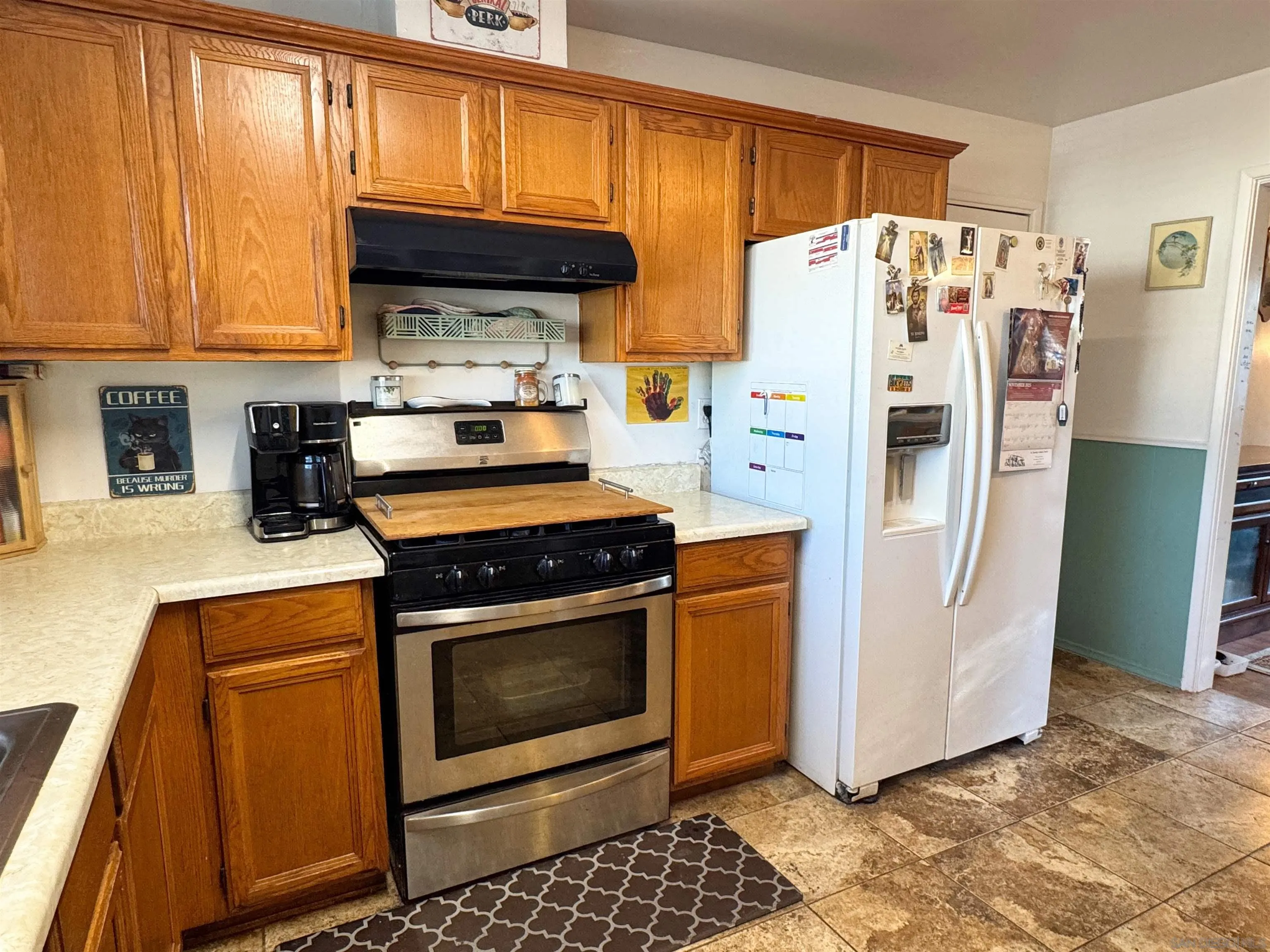 1117 Kings Road Escondido, CA 92027 - Photo 15 of 37 a kitchen with a refrigerator a stove a microwave and cabinets