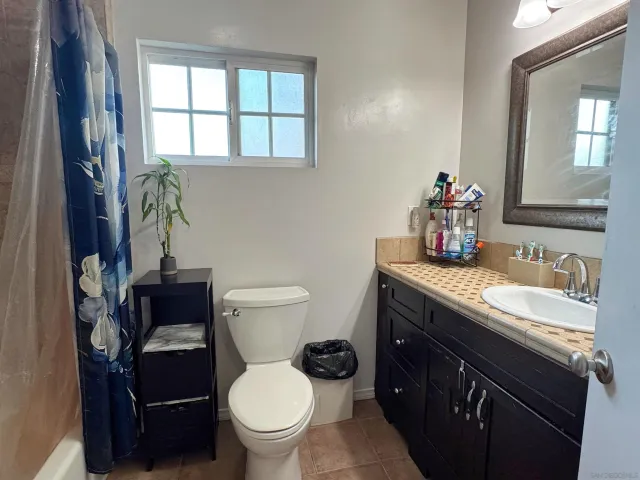 a bathroom with a granite countertop toilet sink and mirror