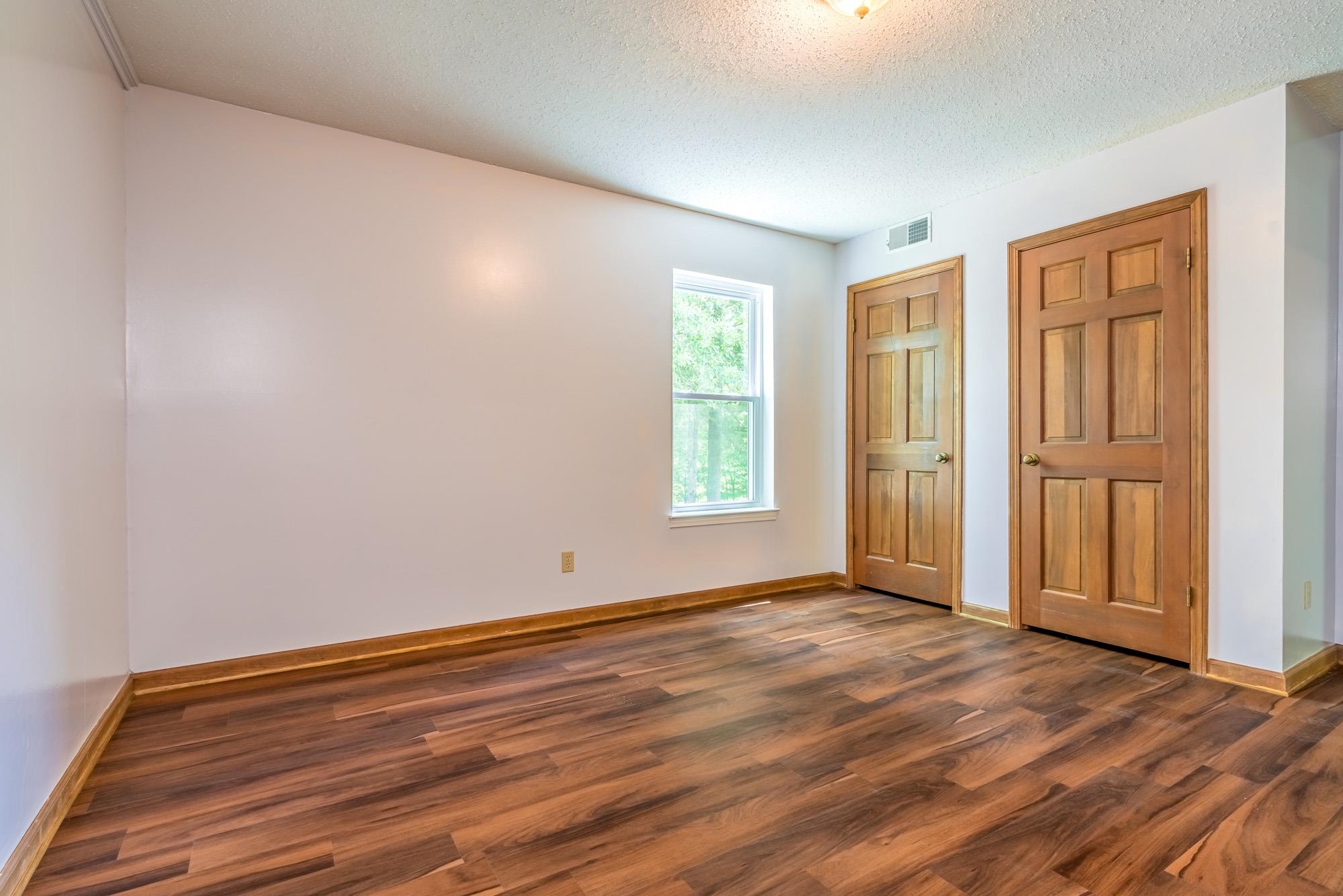 10860 Macedonia Road Brighton, TN 38011 - Photo 13 of 24 a view of an empty room with wooden floor and a window