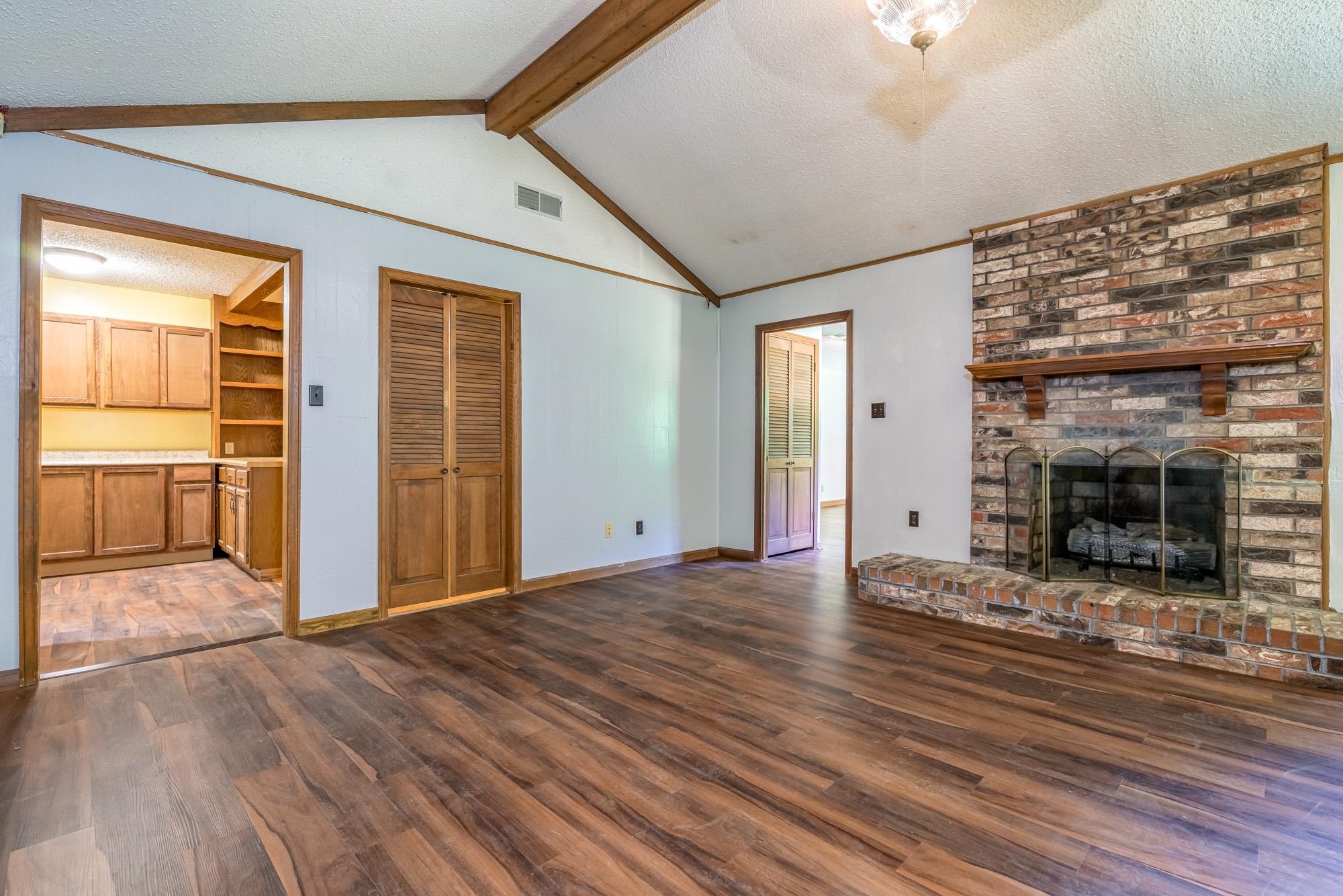 10860 Macedonia Road Brighton, TN 38011 - Photo 4 of 24 an empty room with wooden floor and fireplace
