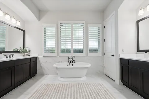 a bathroom with a sink double vanity mirror and a bathtub