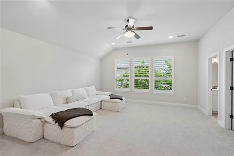 a living room with furniture and ceiling fan