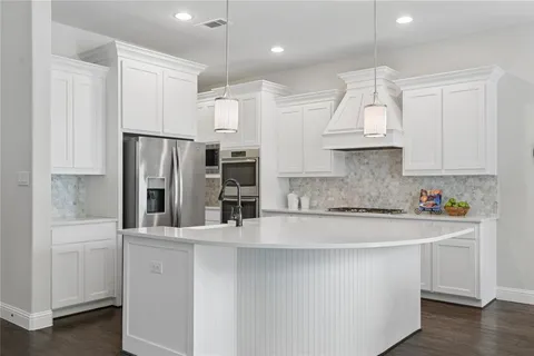 a kitchen with stainless steel appliances granite countertop a refrigerator a sink and a stove