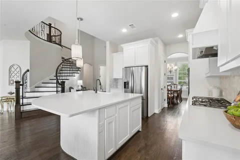 a kitchen with stainless steel appliances granite countertop a refrigerator a stove and a wooden floors